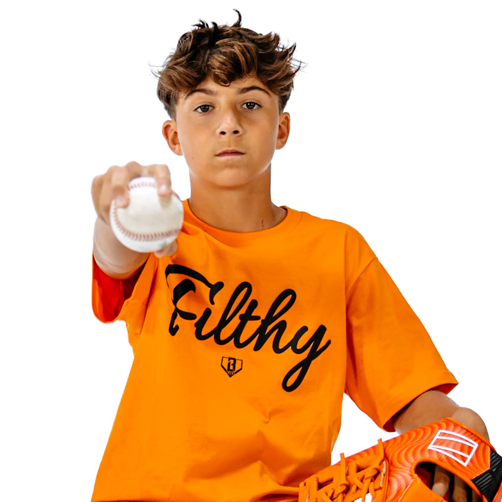 Person wearing an orange shirt with 'Filthy' text, holding a baseball and glove 