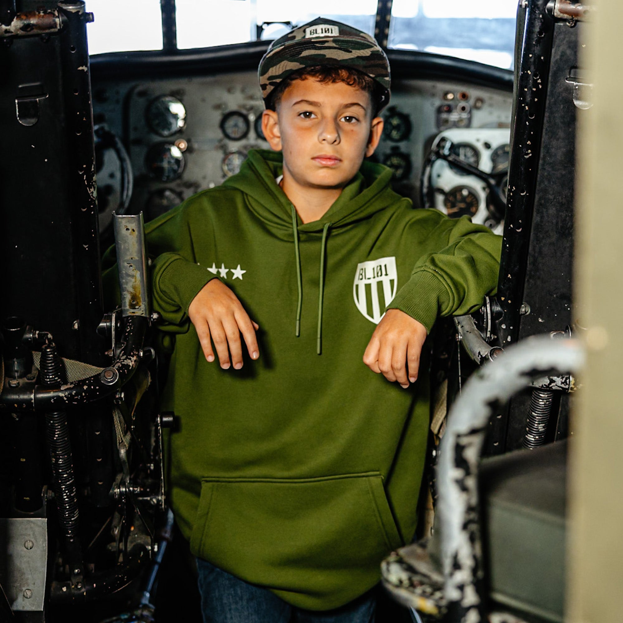Youth model wearing green Flight Deck Army Green youth hoodie
