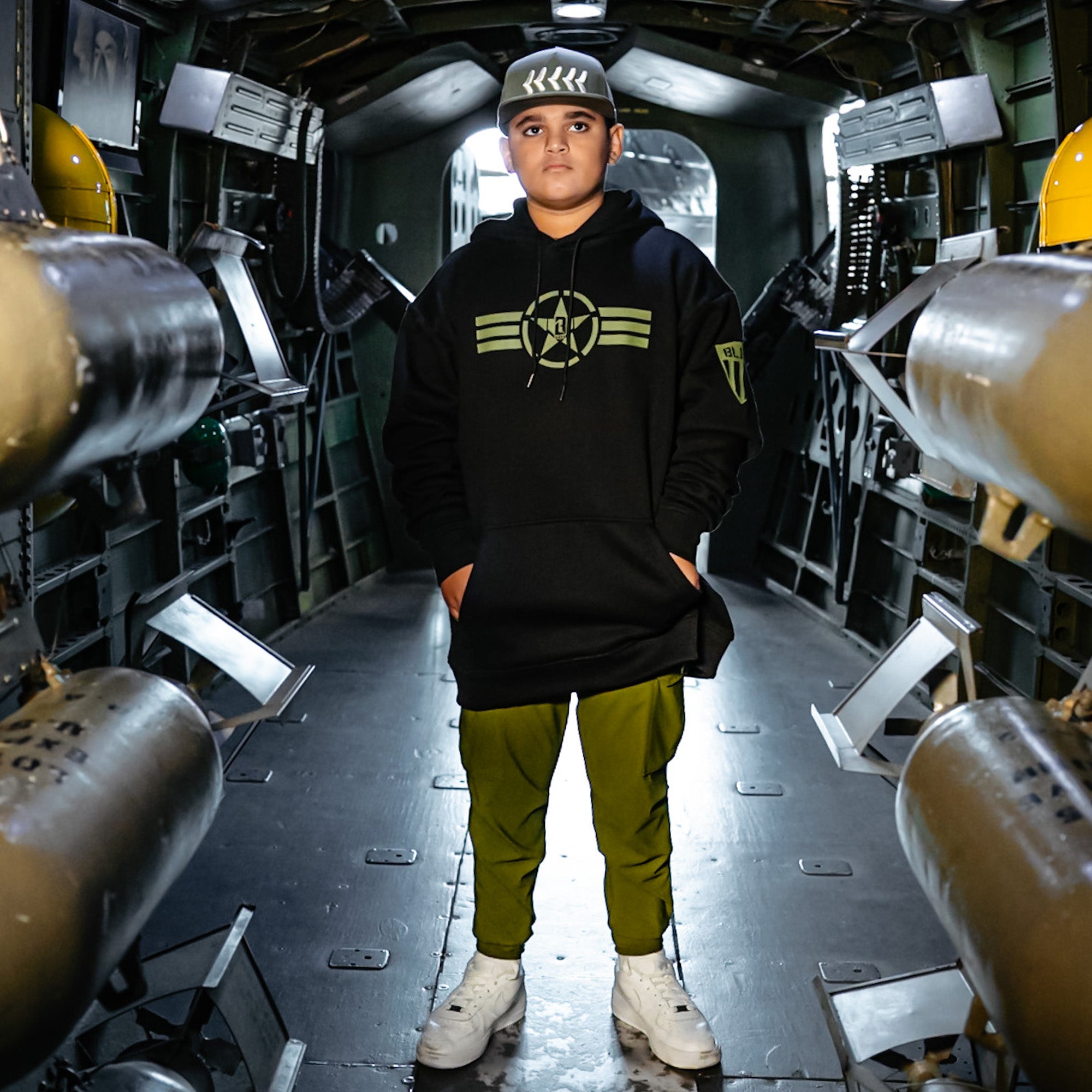 Black Hoodie with, drawstring hood, olive green BL101 star logo on chest and Armor BL101 logo on side

Olive green snapback hat with white embroidered baseball seam stitch design and BL101 logo on the side

Olive green jogger cargo pants with drawstring waist, zippered pockets, utility cargo pockets, and white BL101 embroidered logo on side