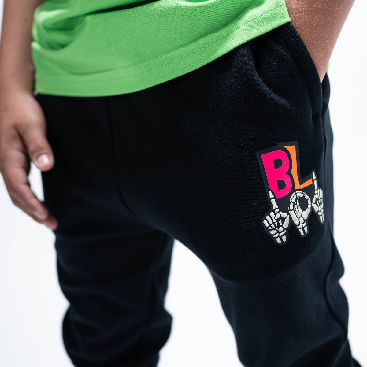 Youth model wearing black youth joggers with "101 Skeleton" design