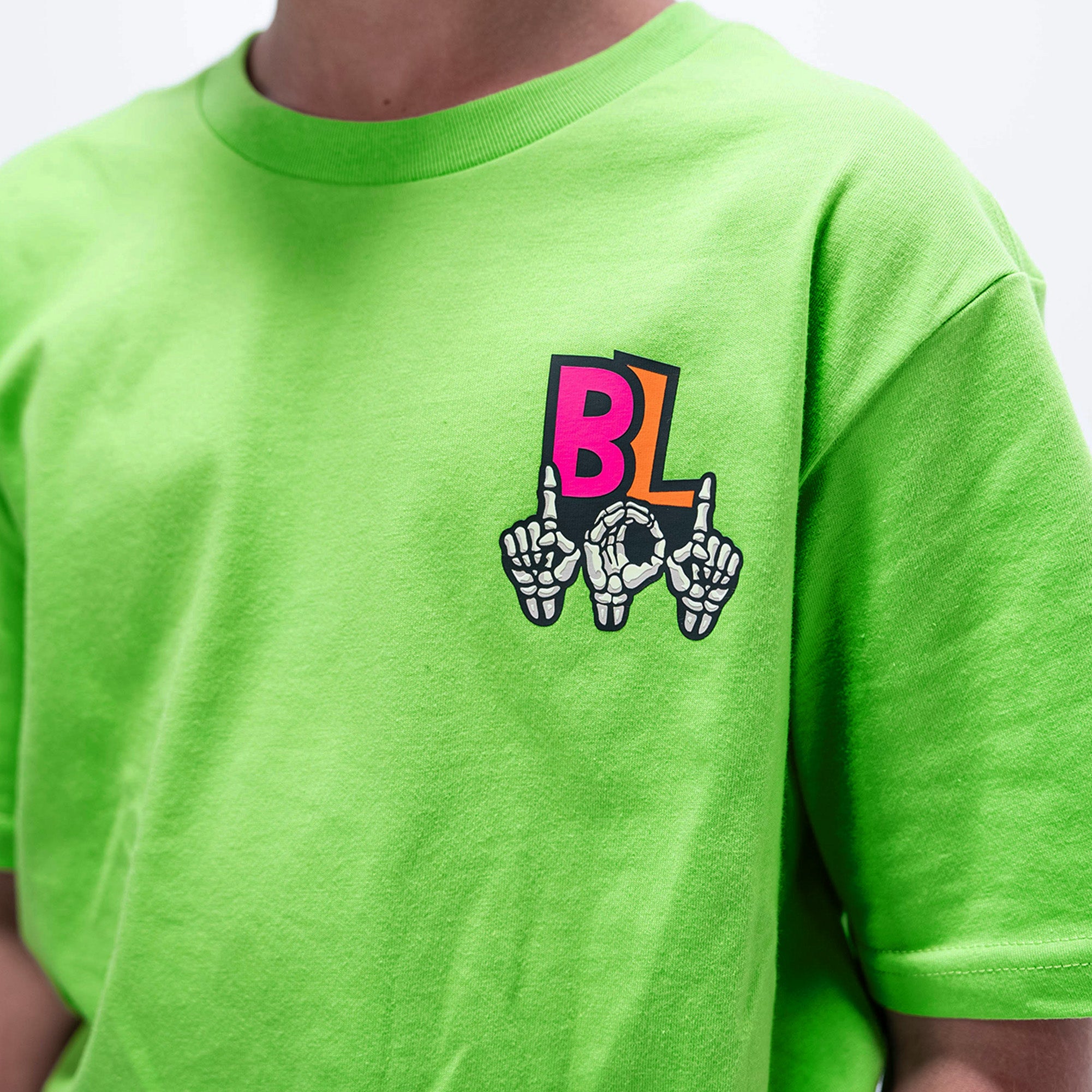 Youth model wearing green youth graphic tee with "101 Skeleton" design