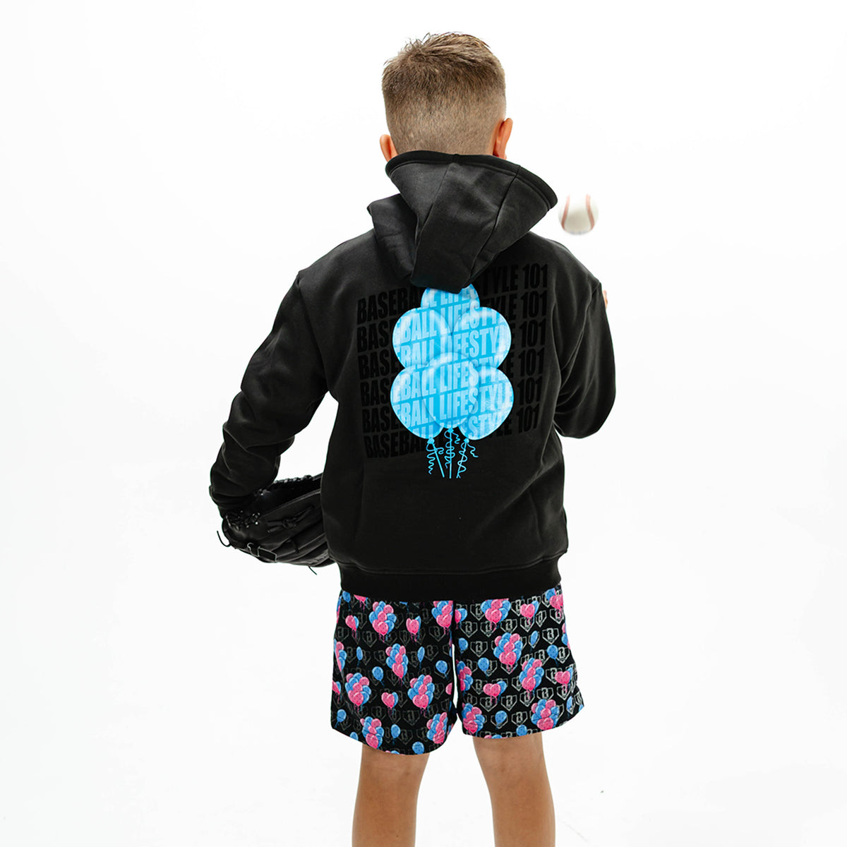 Youth model wearing black youth hoodie with "10 Year Anniversary" design