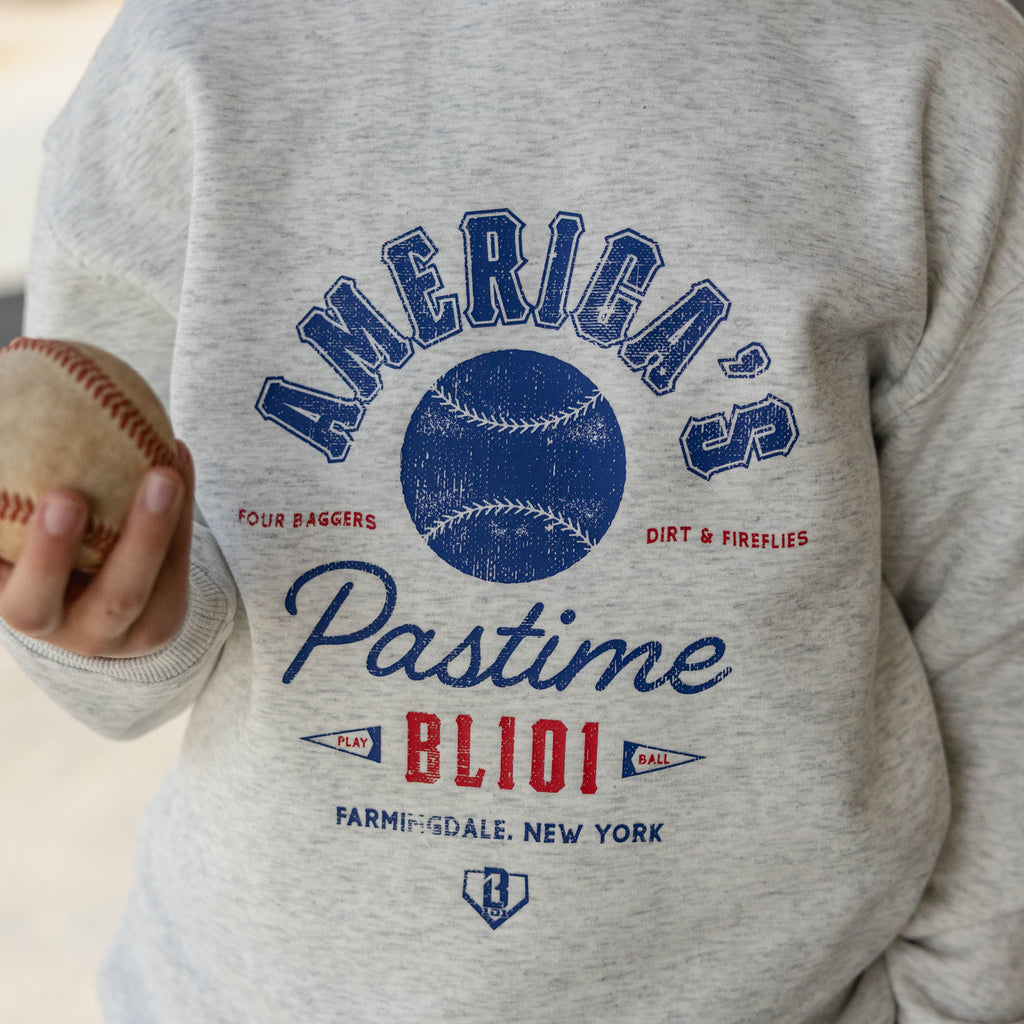 Close up of gray heather America's Pastime crewneck sweatshirt graphic with a baseball held at the side