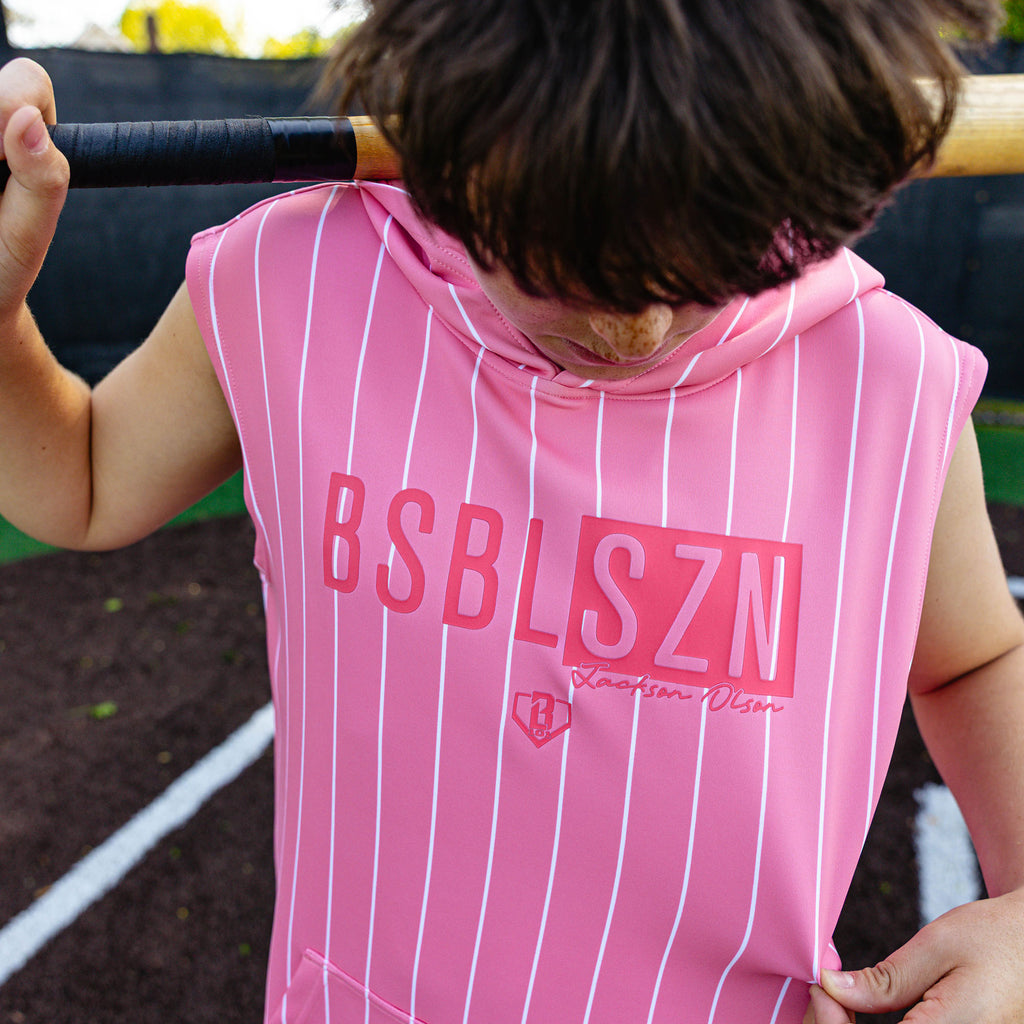 Close-up front view of the youth pink pinstripe BSBL-SZN Short Sleeve Hoodie V3 showing the "BSBLSZN" box logo and "Jackson Olson" script