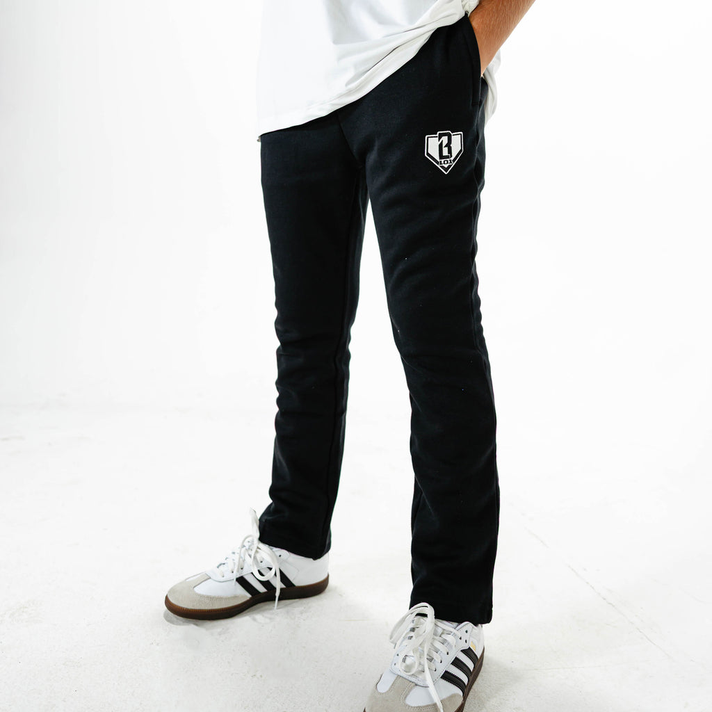 Youth model wearing Black Baseline Straight Leg sweatpants