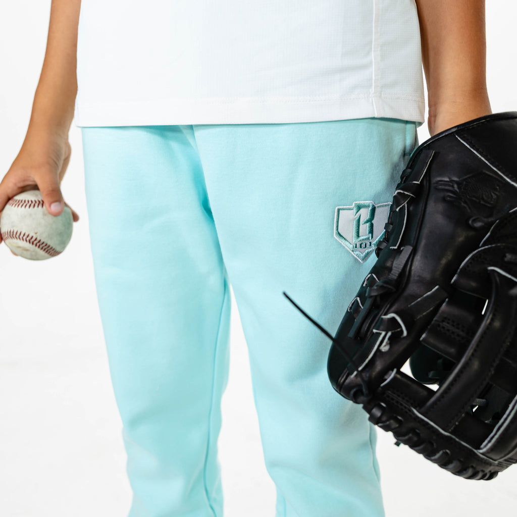 Youth model wearing Blue Baseline Straight Leg sweatpants