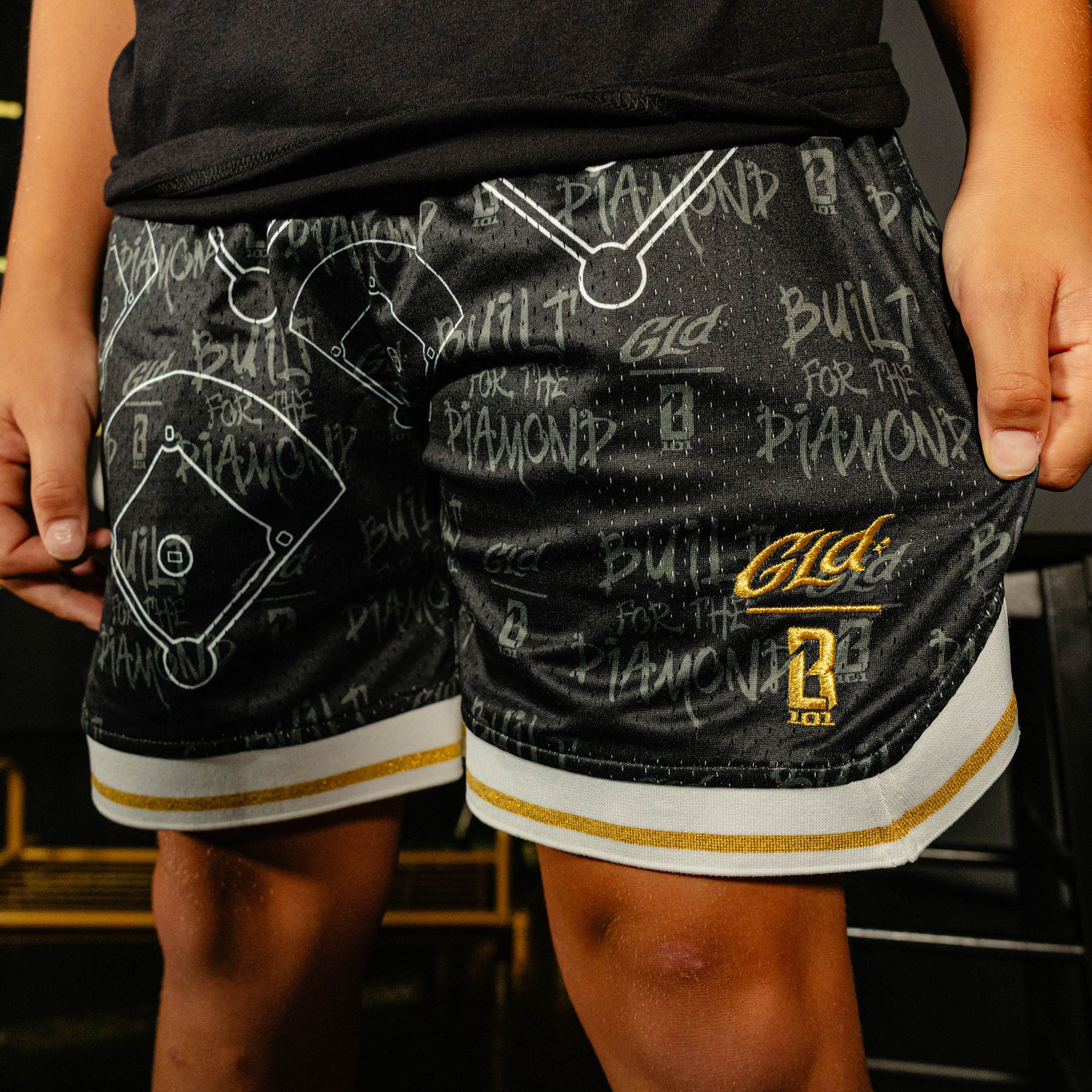 Youth model wearing black youth shorts with "Built For The Diamond" design