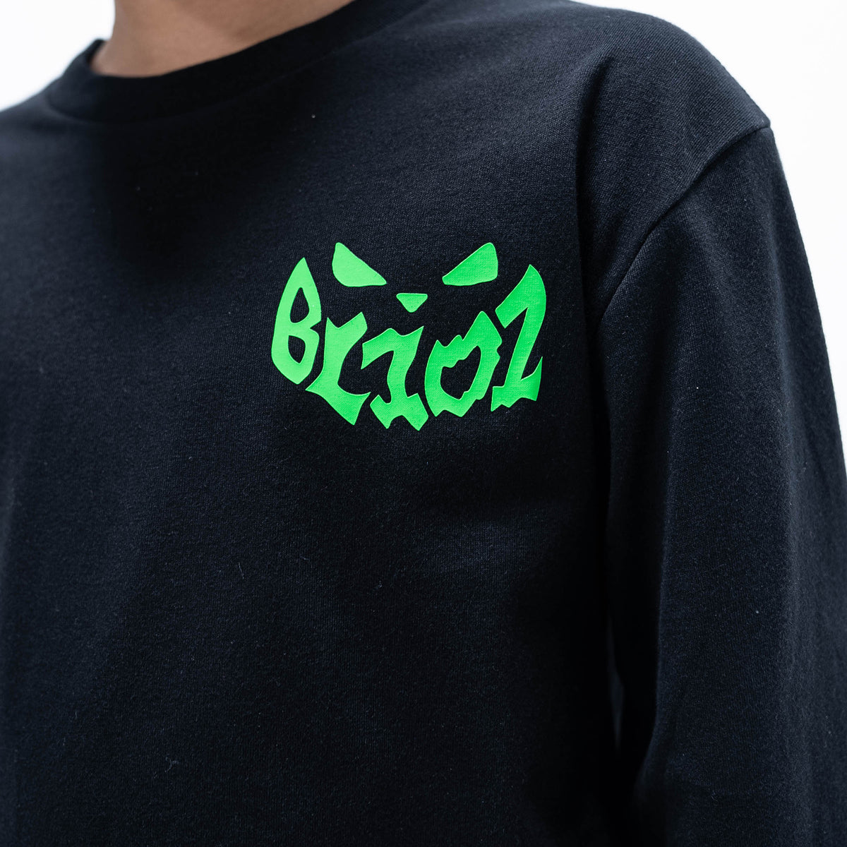 Youth model wearing black youth long sleeve tee with "Jack O' Lantern Team" design