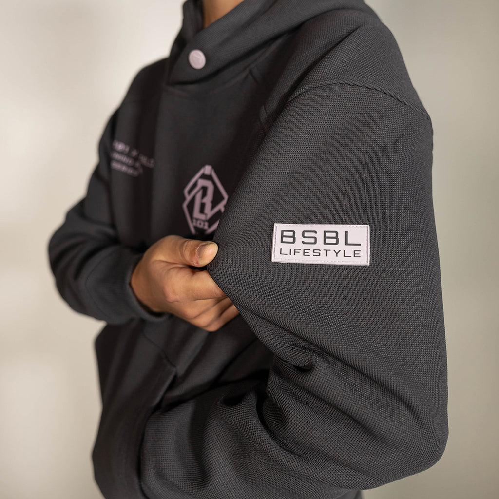 Youth model wearing gray and lilac Off-Field Waffle Performance youth hoodie