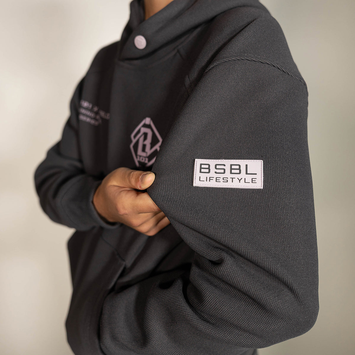 Youth model wearing gray and lilac Off-Field Waffle Performance youth hoodie