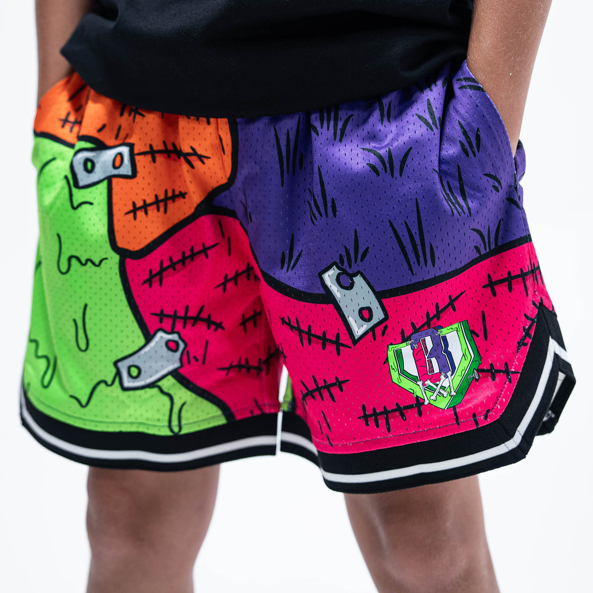 Youth model wearing multi-color youth shorts with "Stitched For The Show" design