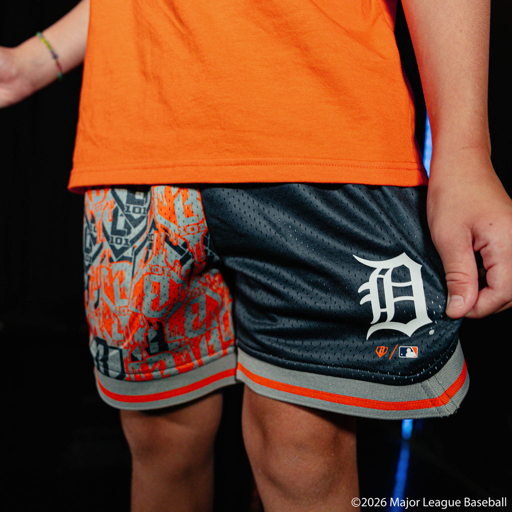 Youth model wearing navy youth shorts with "Detroit Tigers Sticker Court" design