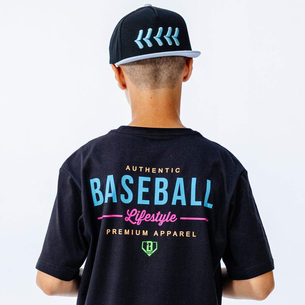 Person wearing a black t-shirt with 'Authentic Baseball Lifestyle Premium Apparel' text and a cap on a white background