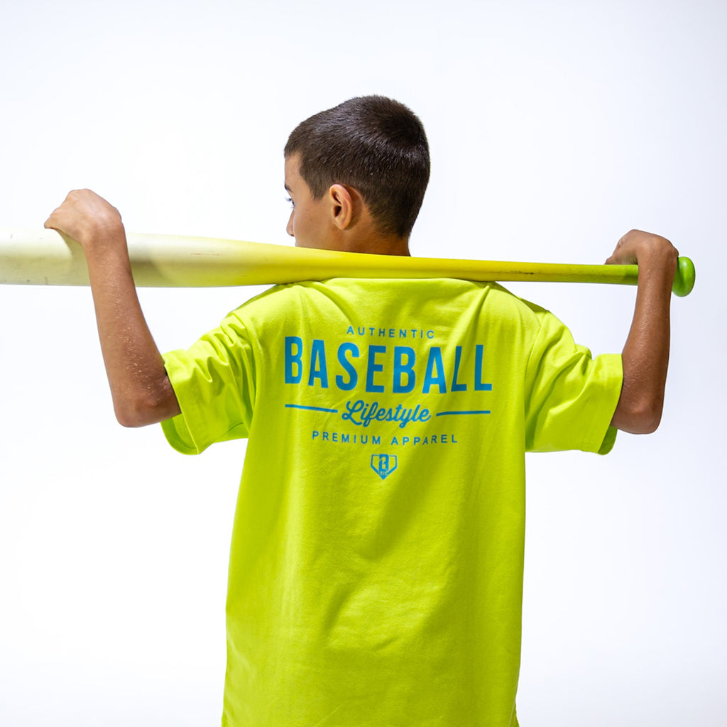 Person wearing a bright yellow 'Baseball Lifestyle' t-shirt holding a baseball bat on a white background