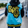 Person wearing a blue and black jacket with yellow BL101 logo outdoors