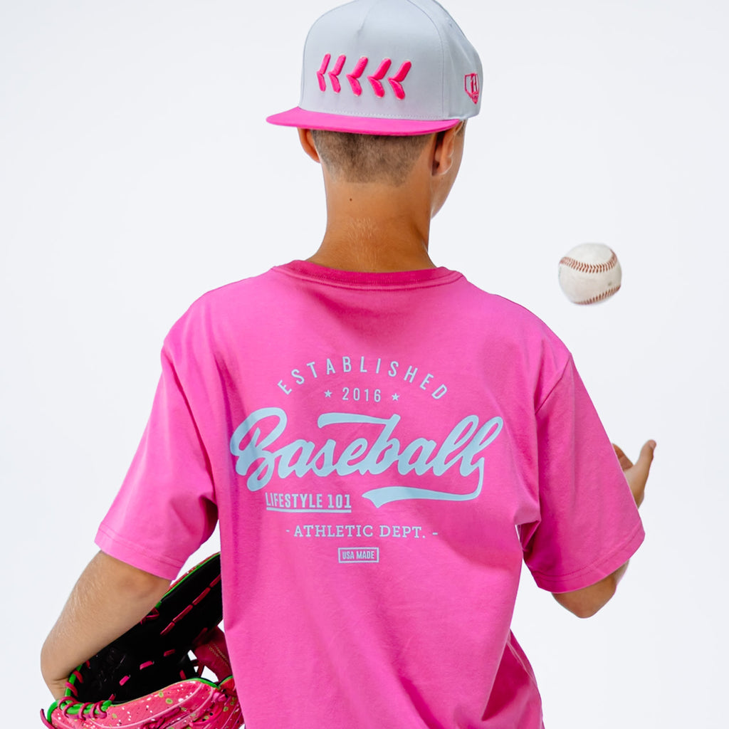 Person wearing a pink 'Baseball' t-shirt and cap, holding a baseball and glove on a white background