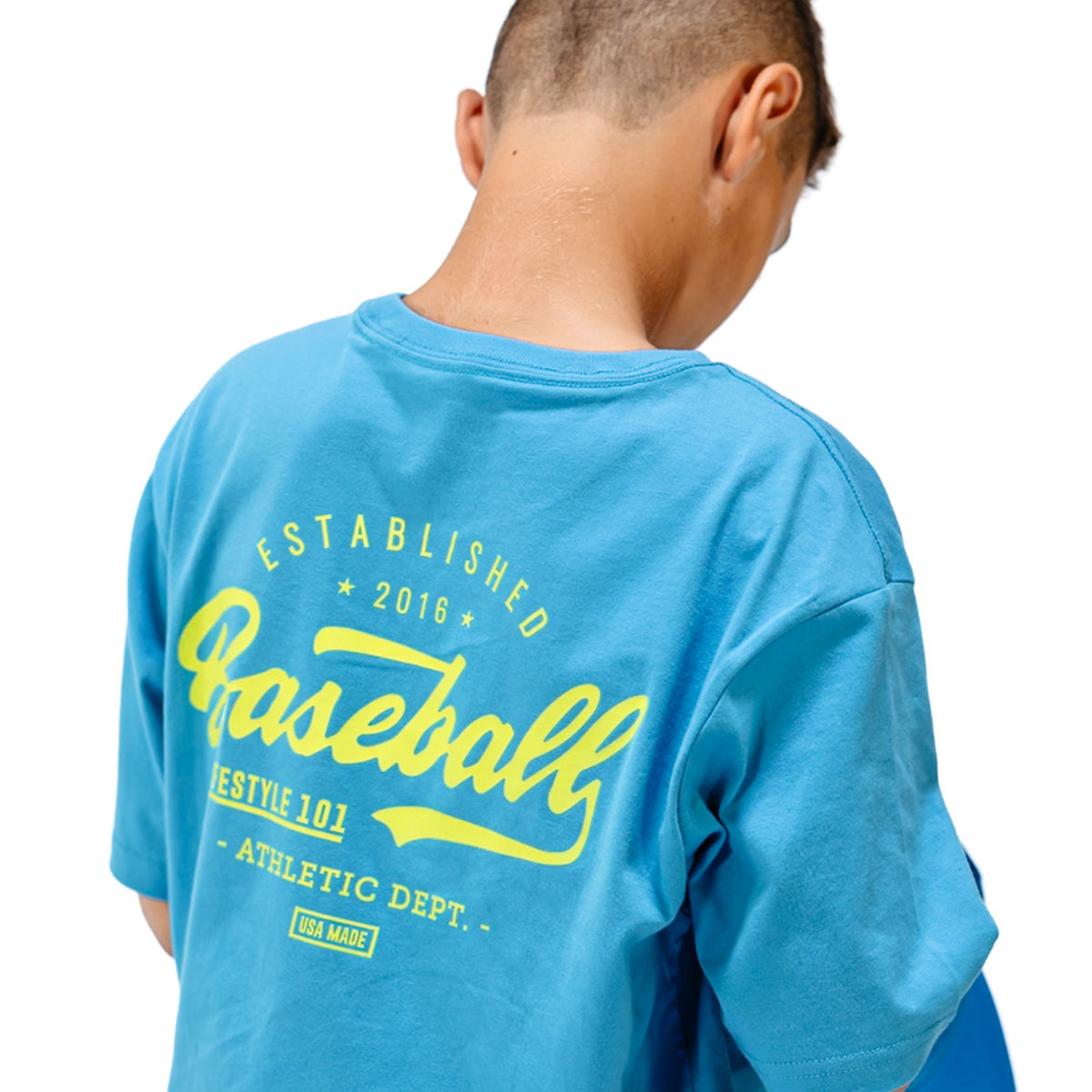 Person wearing a blue t-shirt with yellow 'Baseball Lifestyle 101' text on the back