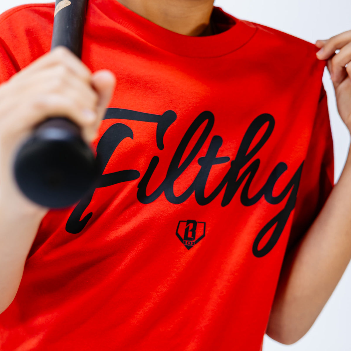 Red t-shirt with 'Filthy' printed in black on a white background