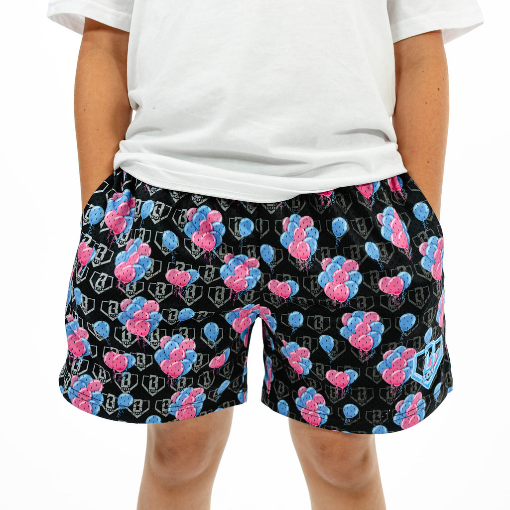 Youth model wearing blue youth shorts with "10 Year Anniversary" design