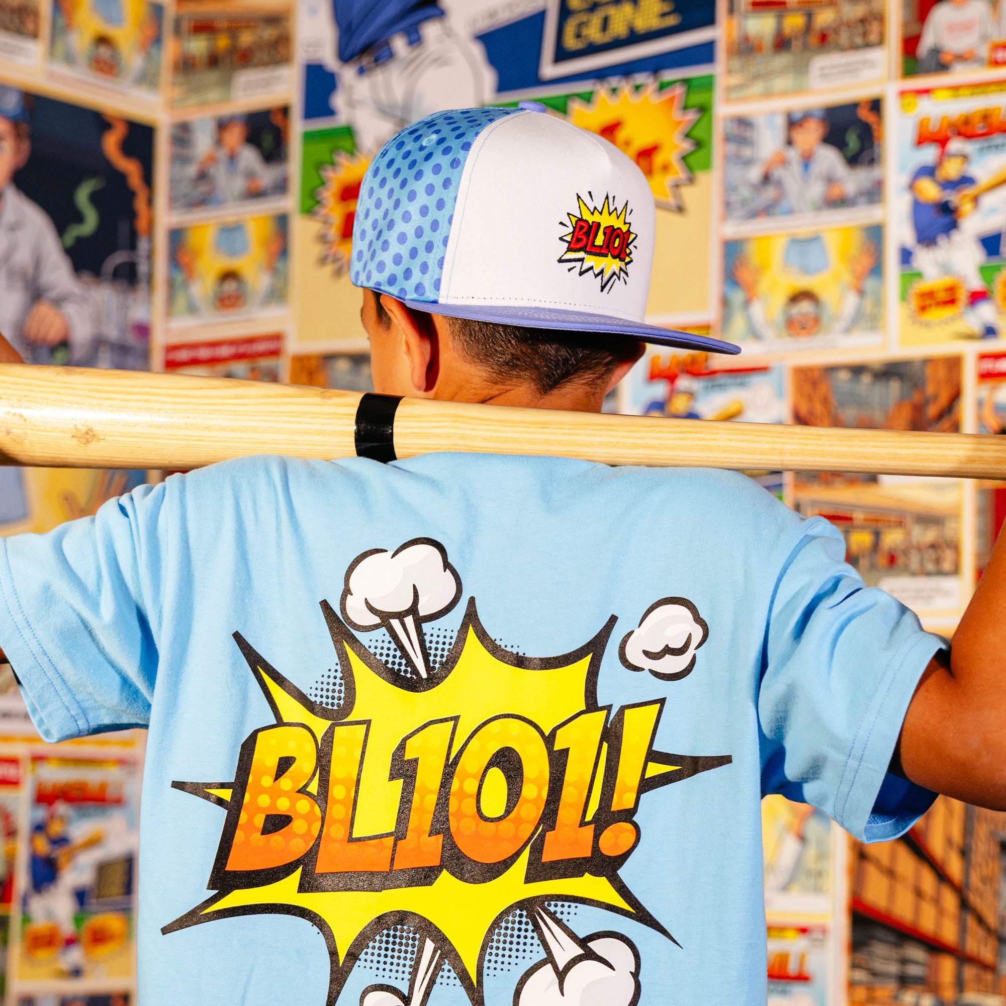 Youth model wearing blue hat with "BL101 Comic" design