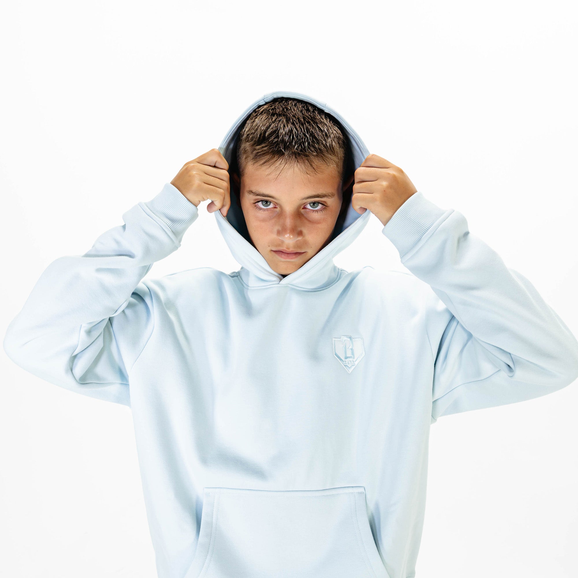 Youth model wearing Blue Baseline hoodie