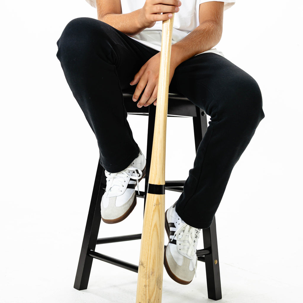Youth model wearing Black Baseline Straight Leg sweatpants
