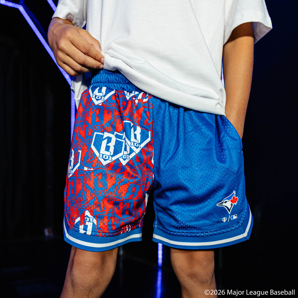Youth model wearing blue youth shorts with "Toronto Blue Jays Sticker Court" design