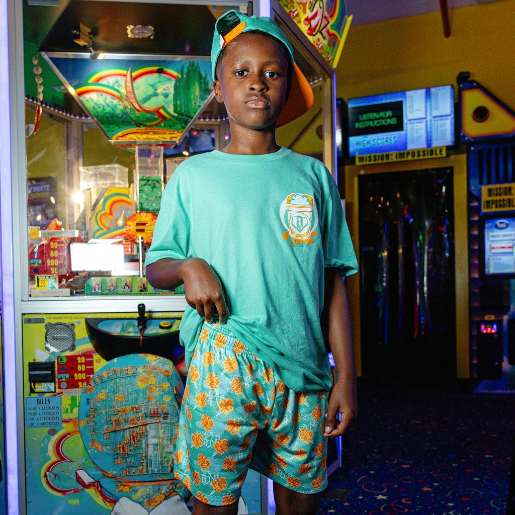 Youth model wearing Home Run Sugar Tangerine Freeze youth shorts