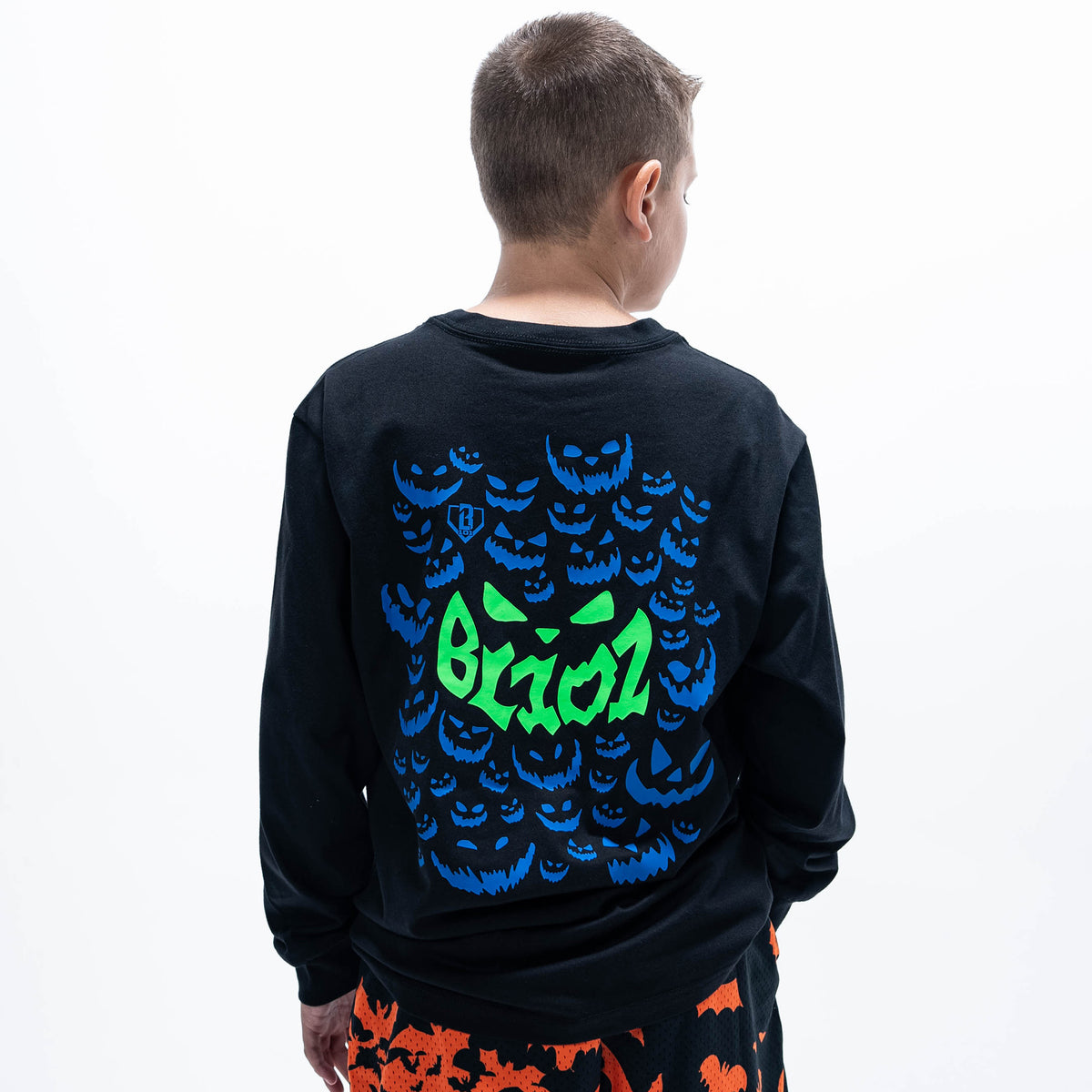 Youth model wearing black youth long sleeve tee with "Jack O' Lantern Team" design