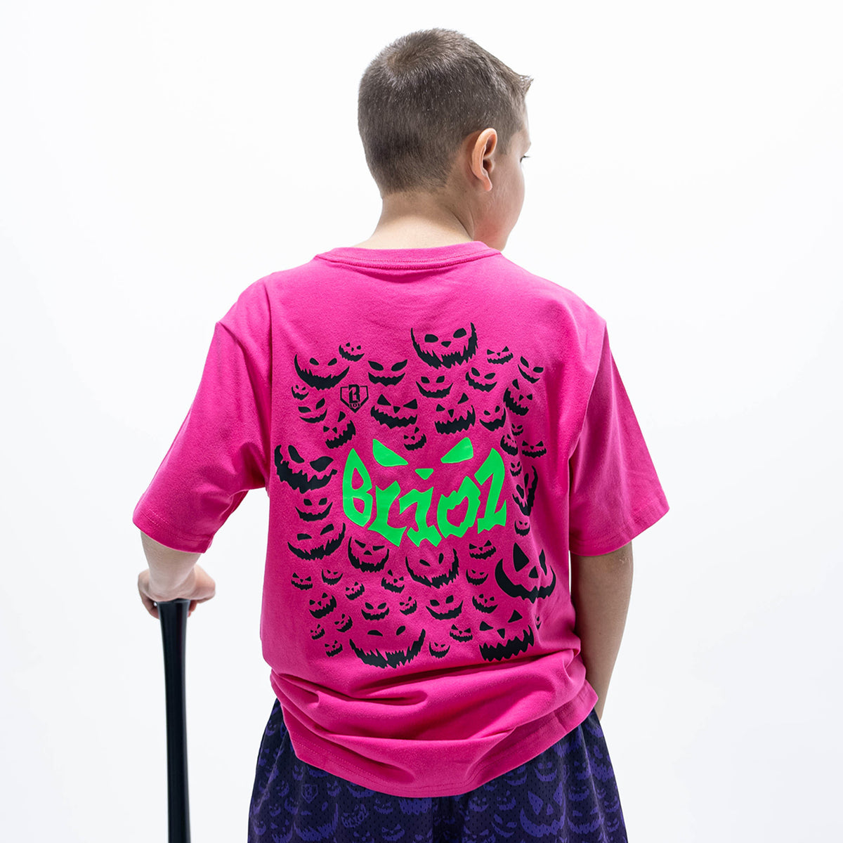 Youth model wearing pink youth graphic tee with "Jack O' Lantern Team" design