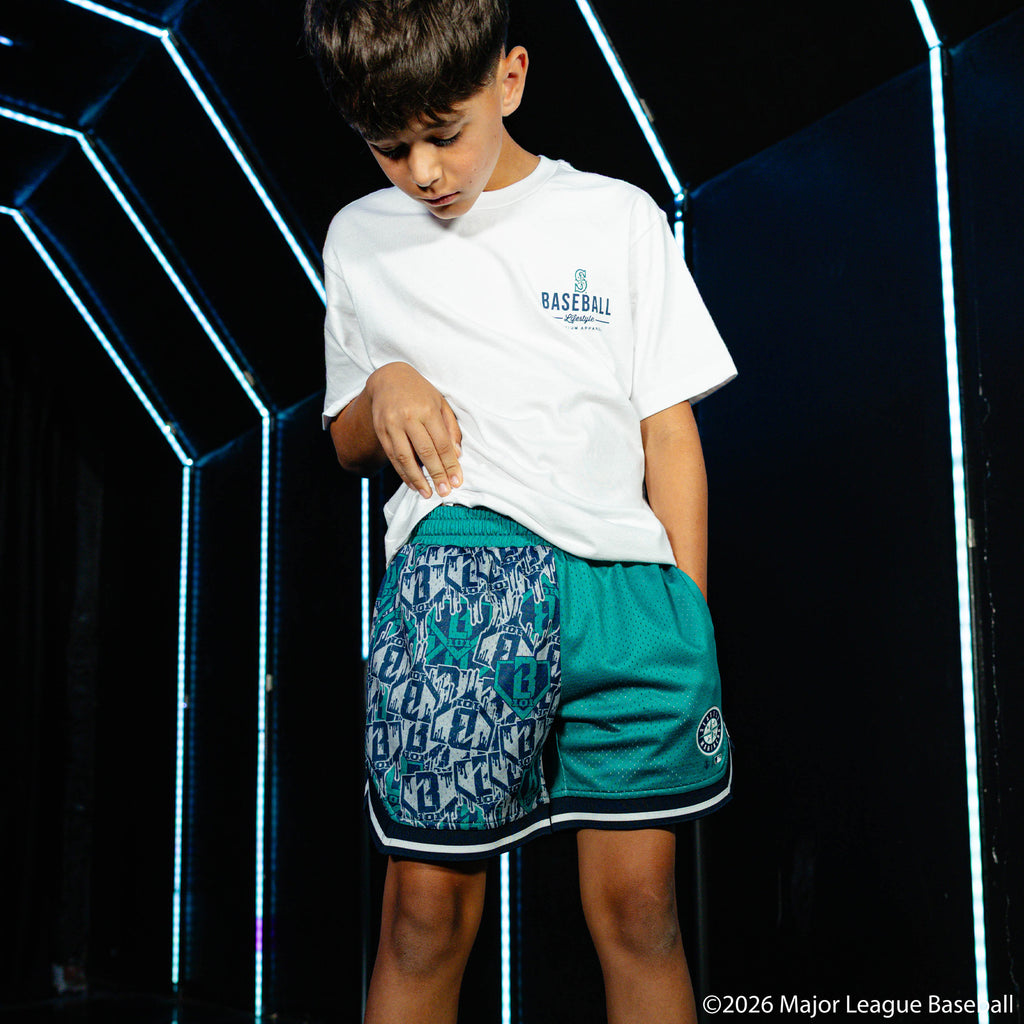 Youth model wearing green youth shorts with "Seattle Mariners Sticker Court" design