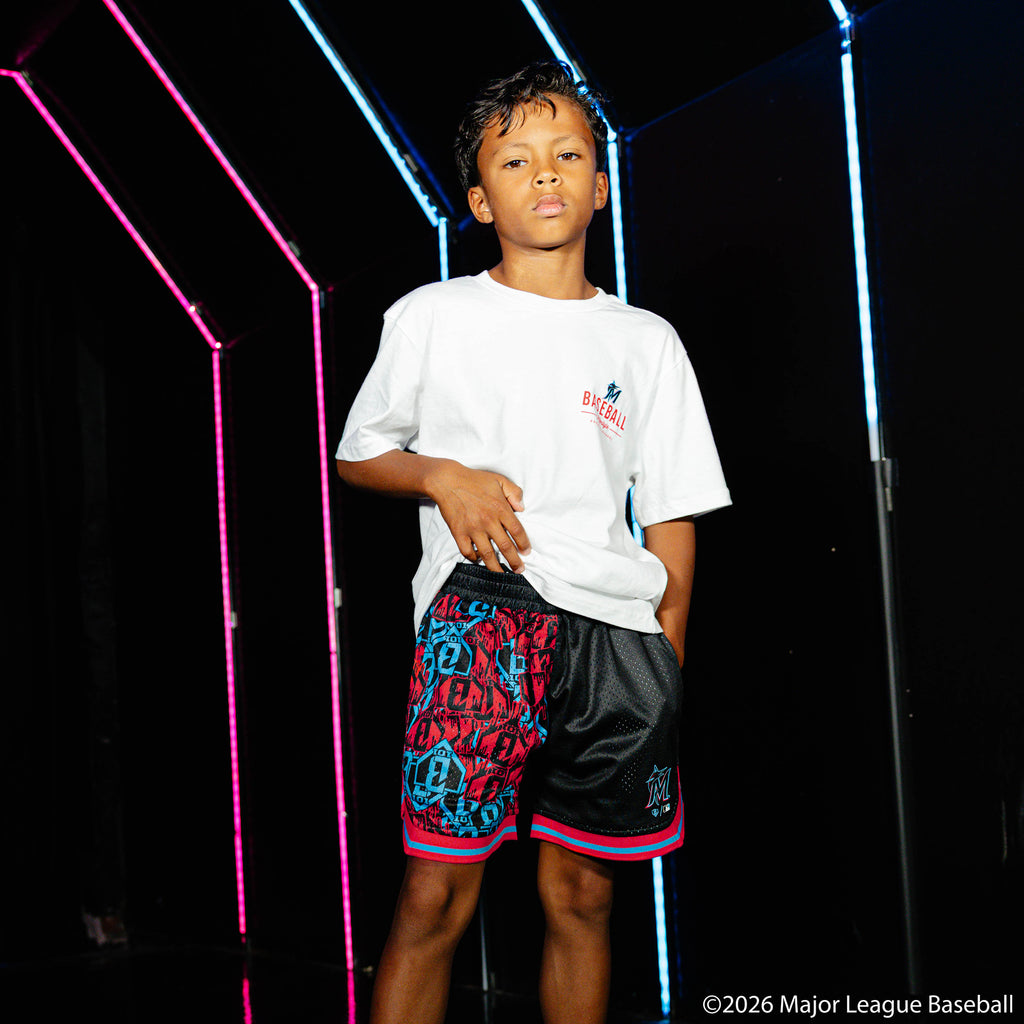 Youth model wearing black youth shorts with "Miami Marlins Sticker Court" design