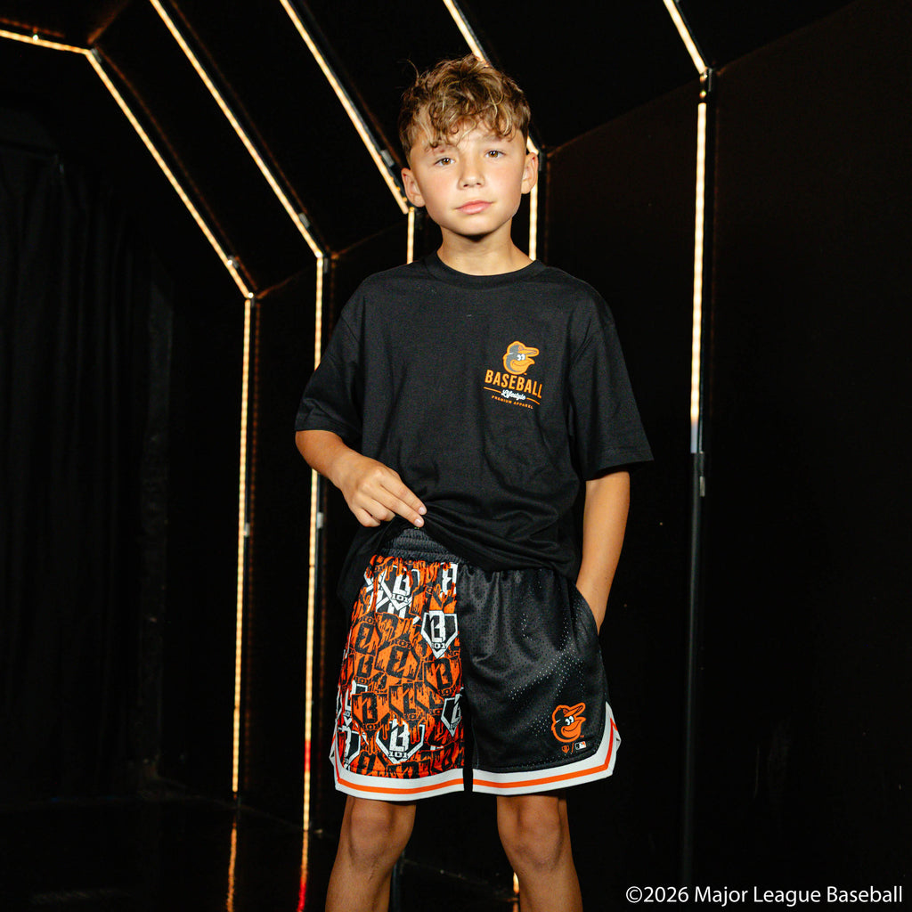 Youth model wearing black youth shorts with "Baltimore Orioles Sticker Court" design