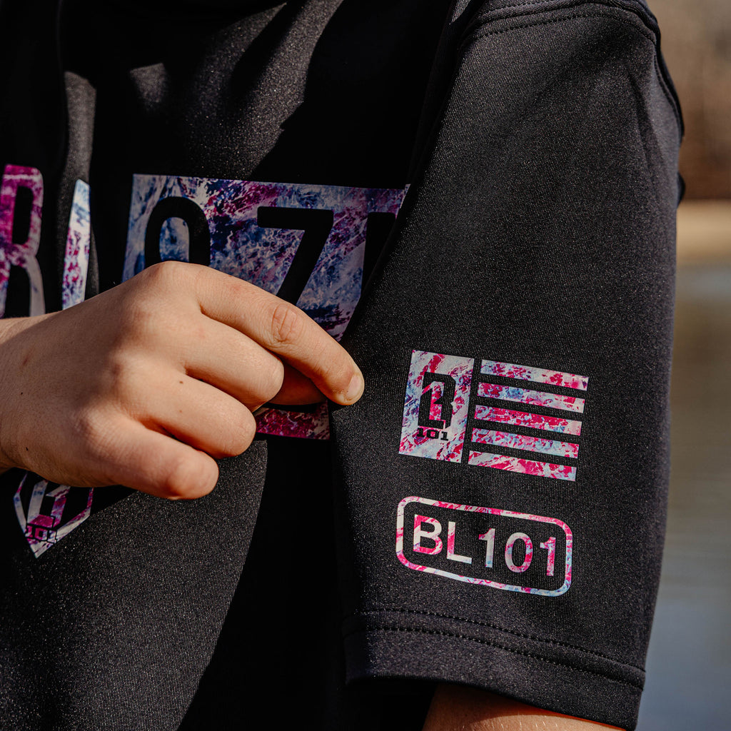Black hoodie with colorful 'BL101' logo on sleeve, held by a person.