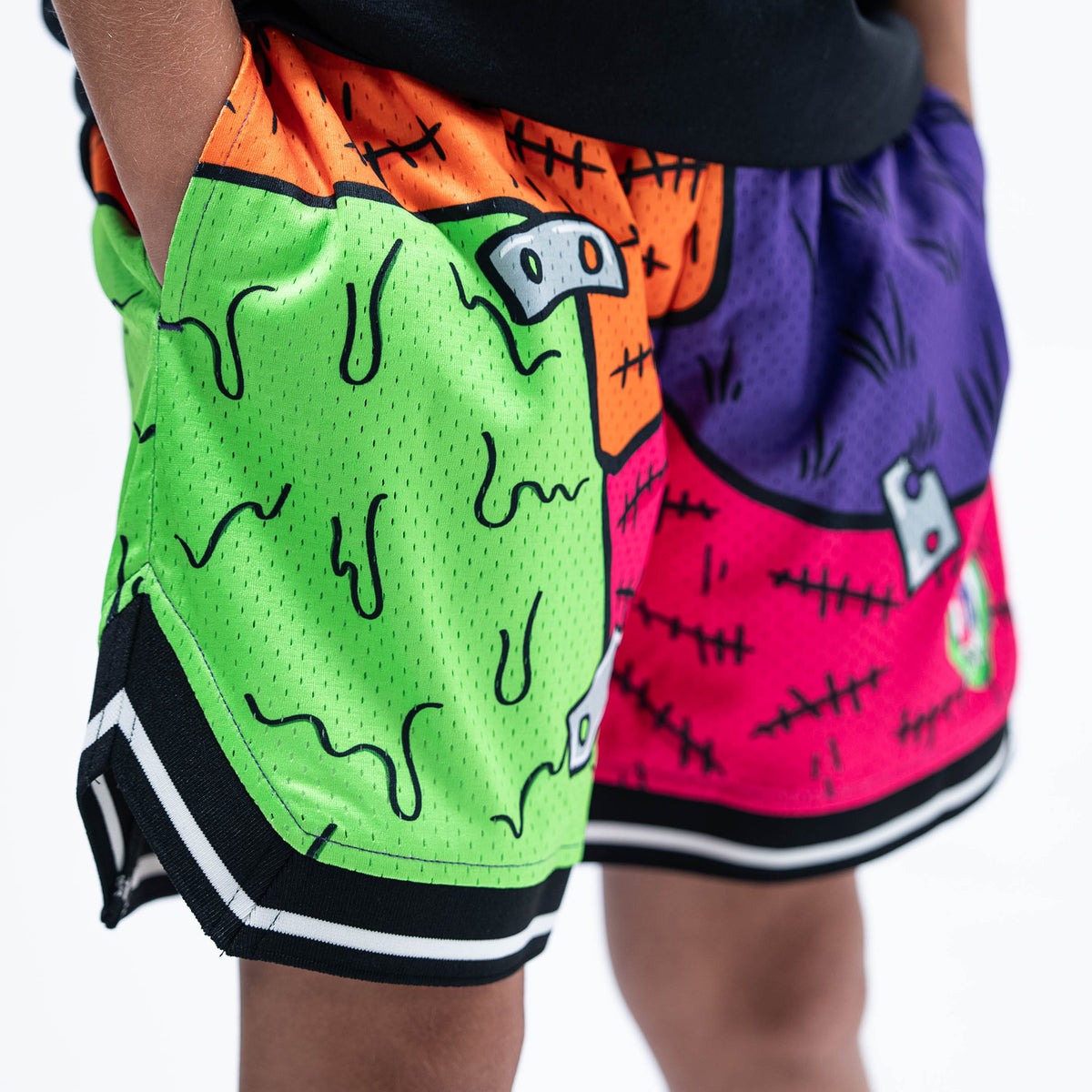 Youth model wearing multi-color youth shorts with "Stitched For The Show" design