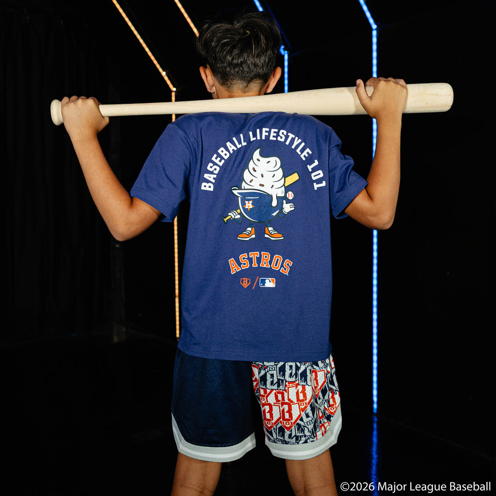 Youth model wearing blue youth shorts with "Houston Astros Sticker Court" design