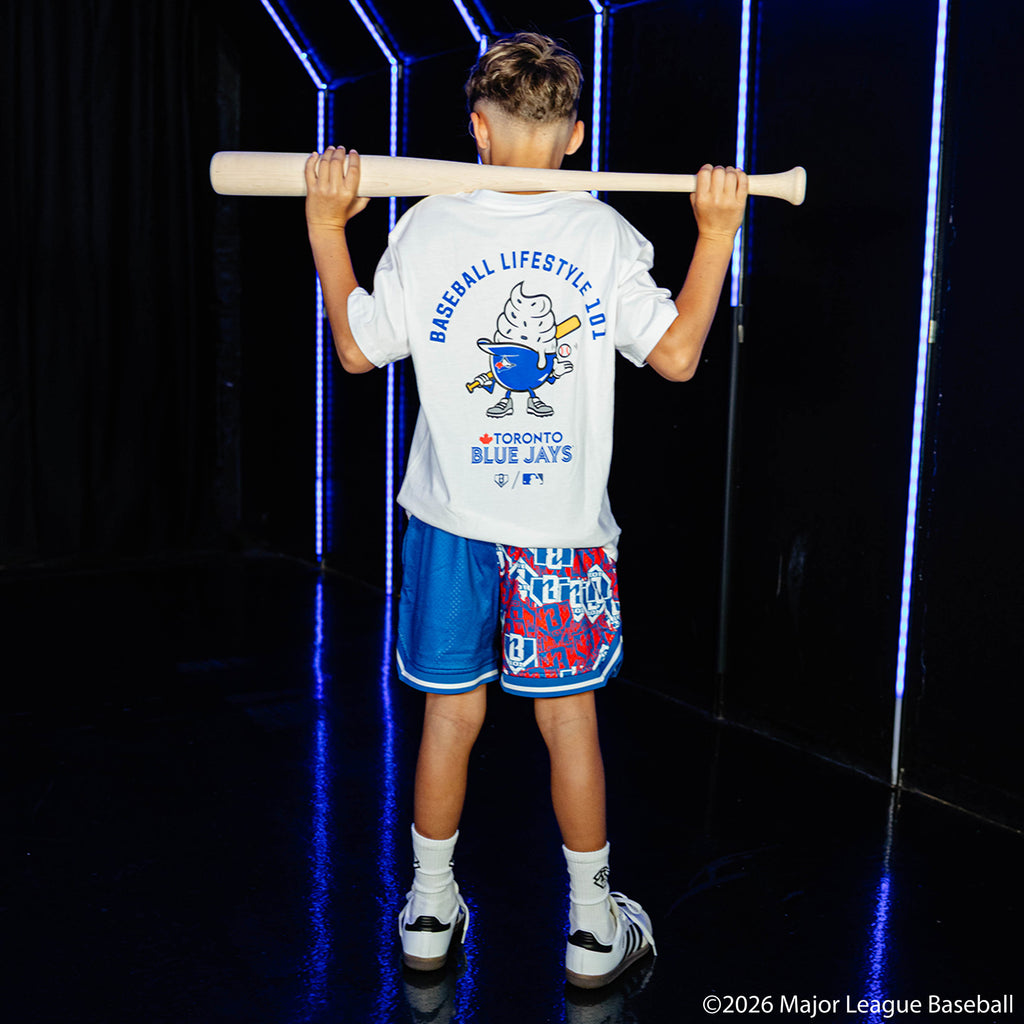 Youth model wearing blue youth shorts with "Toronto Blue Jays Sticker Court" design