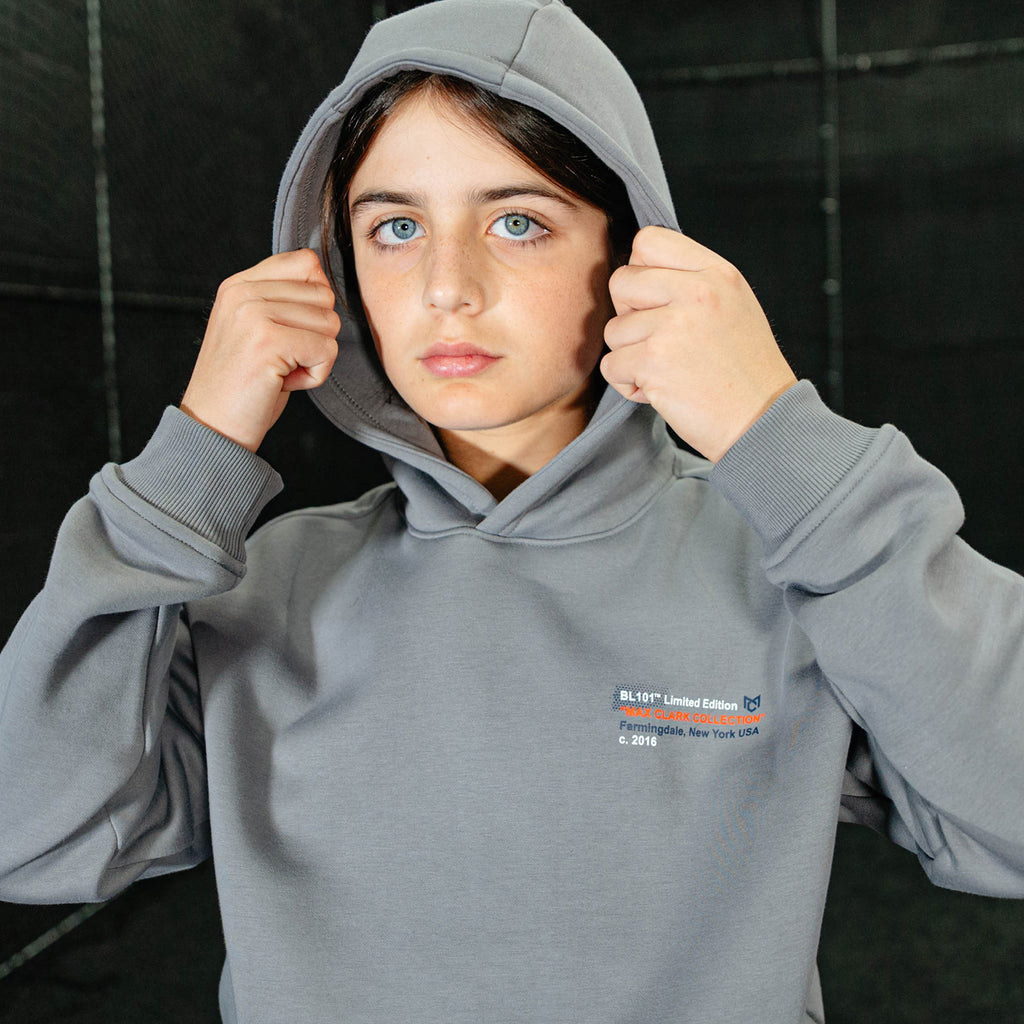 Person wearing a gray hoodie with a logo on a black background