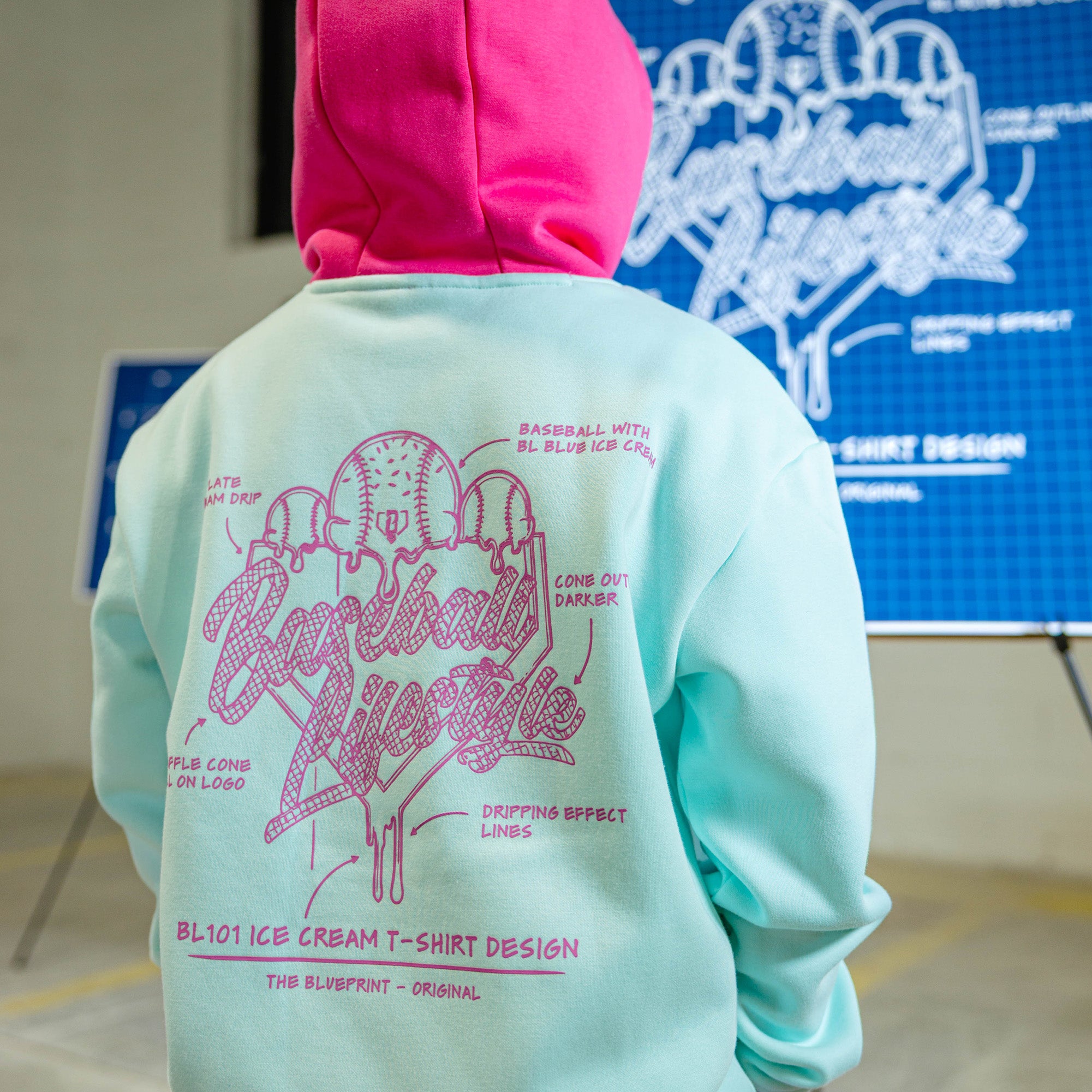 Child in light blue hoodie with pink hood and pink BL101 Ice cream logo