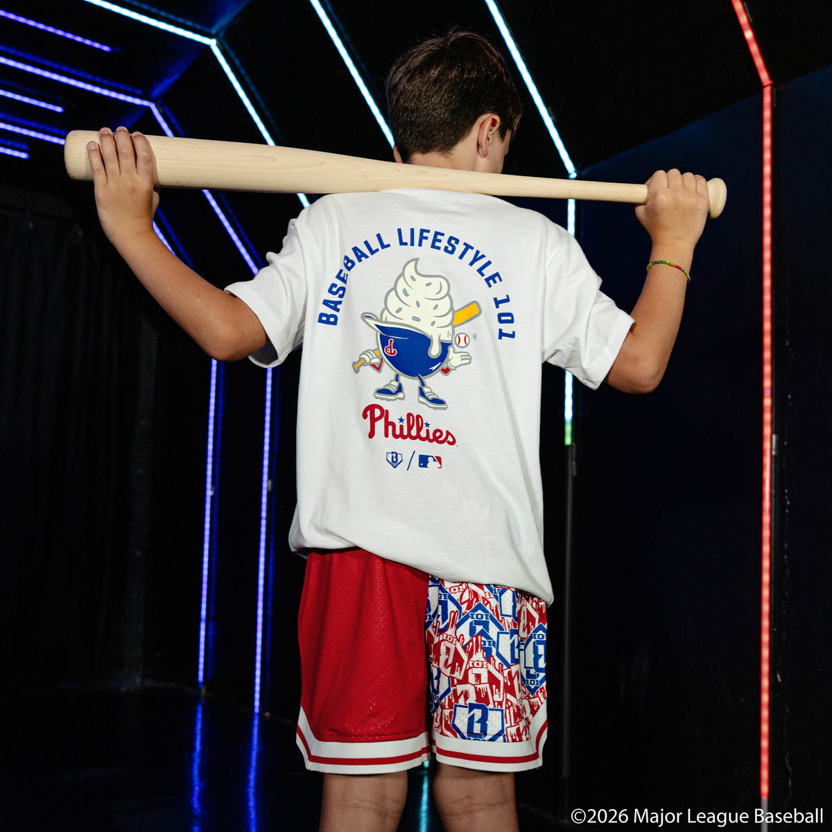 Youth model wearing red youth shorts with "Philadelphia Phillies Sticker Court" design