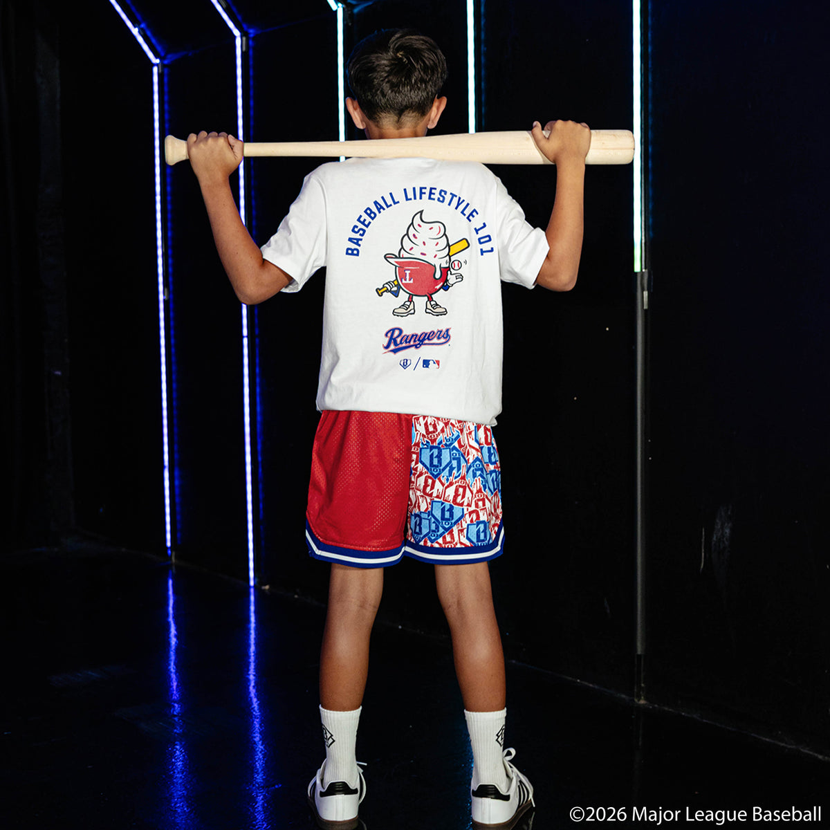 Youth model wearing red youth shorts with "Texas Rangers Sticker Court" design