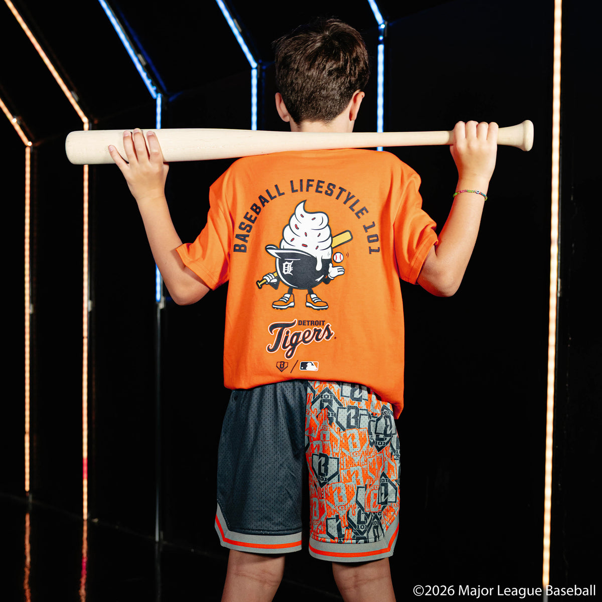 Youth model wearing navy youth shorts with "Detroit Tigers Sticker Court" design