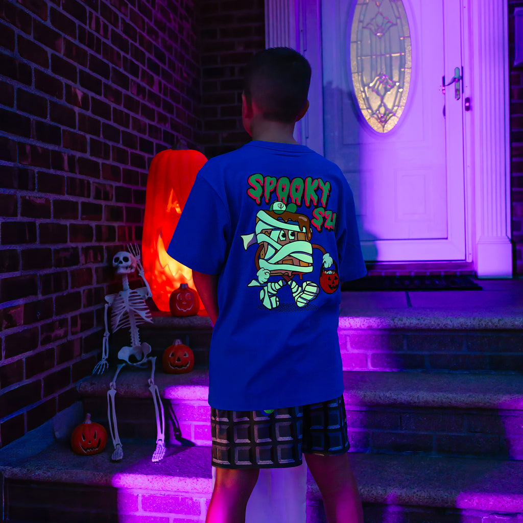 Youth model wearing blue youth graphic tee with "Spooky SZN Waffle" design
