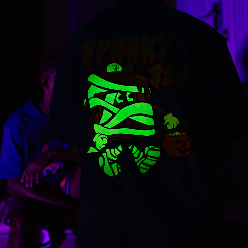 Youth model wearing blue youth graphic tee with "Spooky SZN Waffle" design