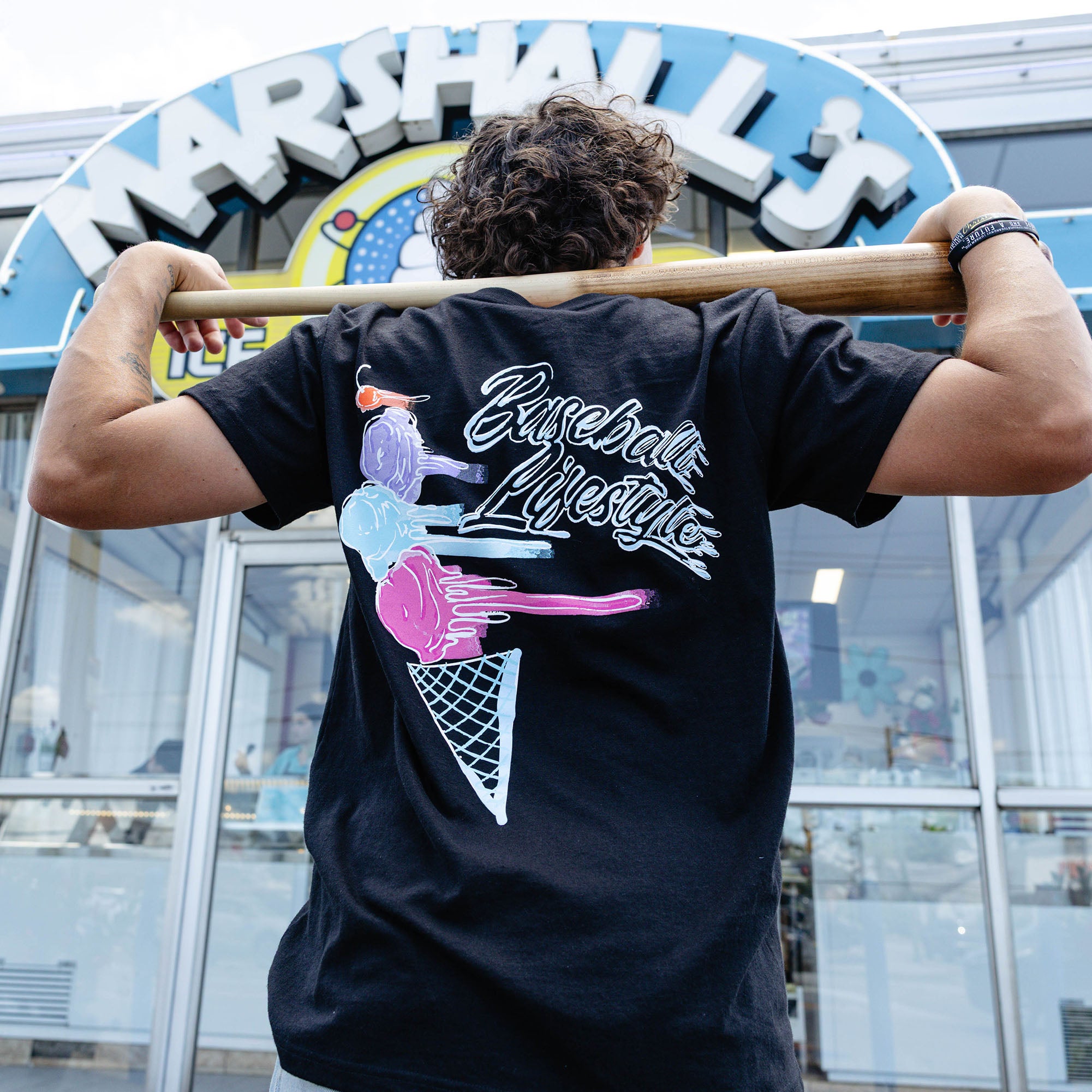 Adult model wearing black Fastball Scoops graphic tee