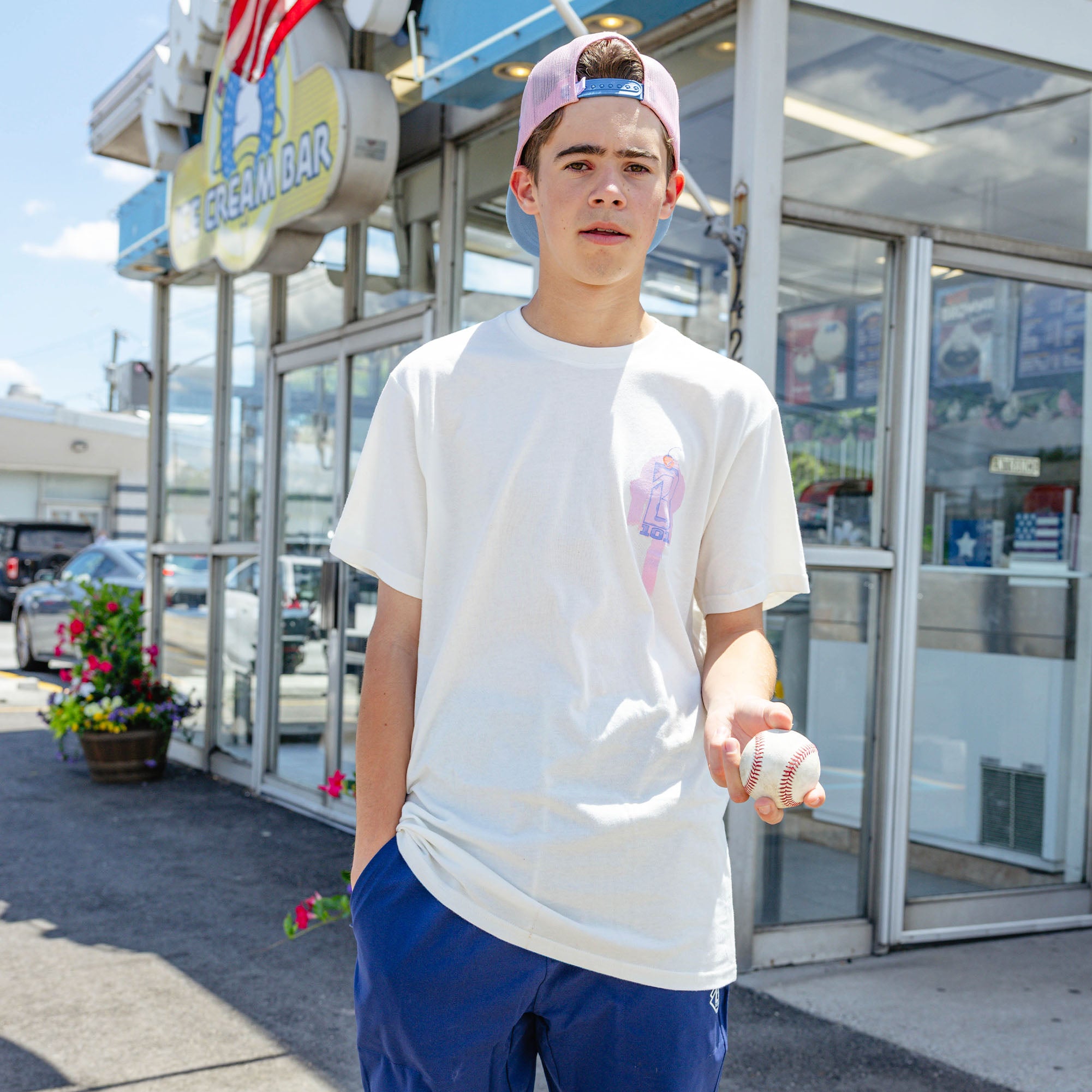 Adult model wearing cream Fastball Scoops graphic tee