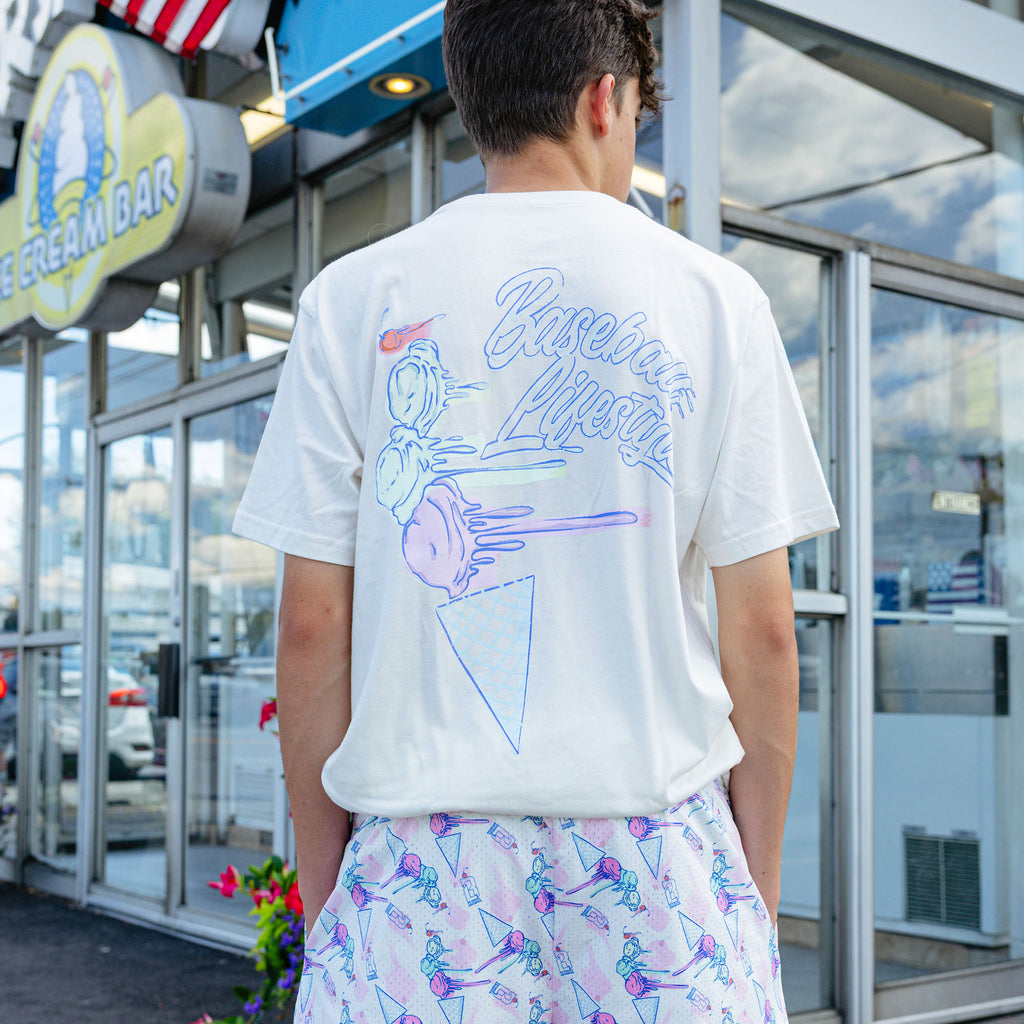 Adult model wearing cream Fastball Scoops graphic tee