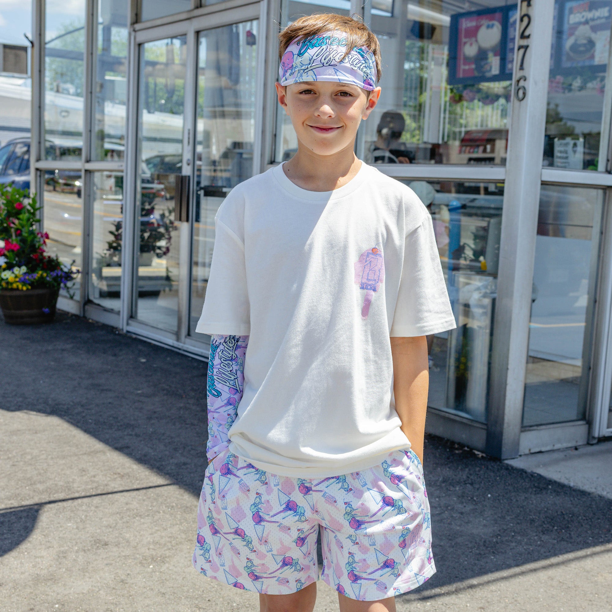 Youth model wearing youth sleeve with "Fastball Scoops Arm Sleeve" design