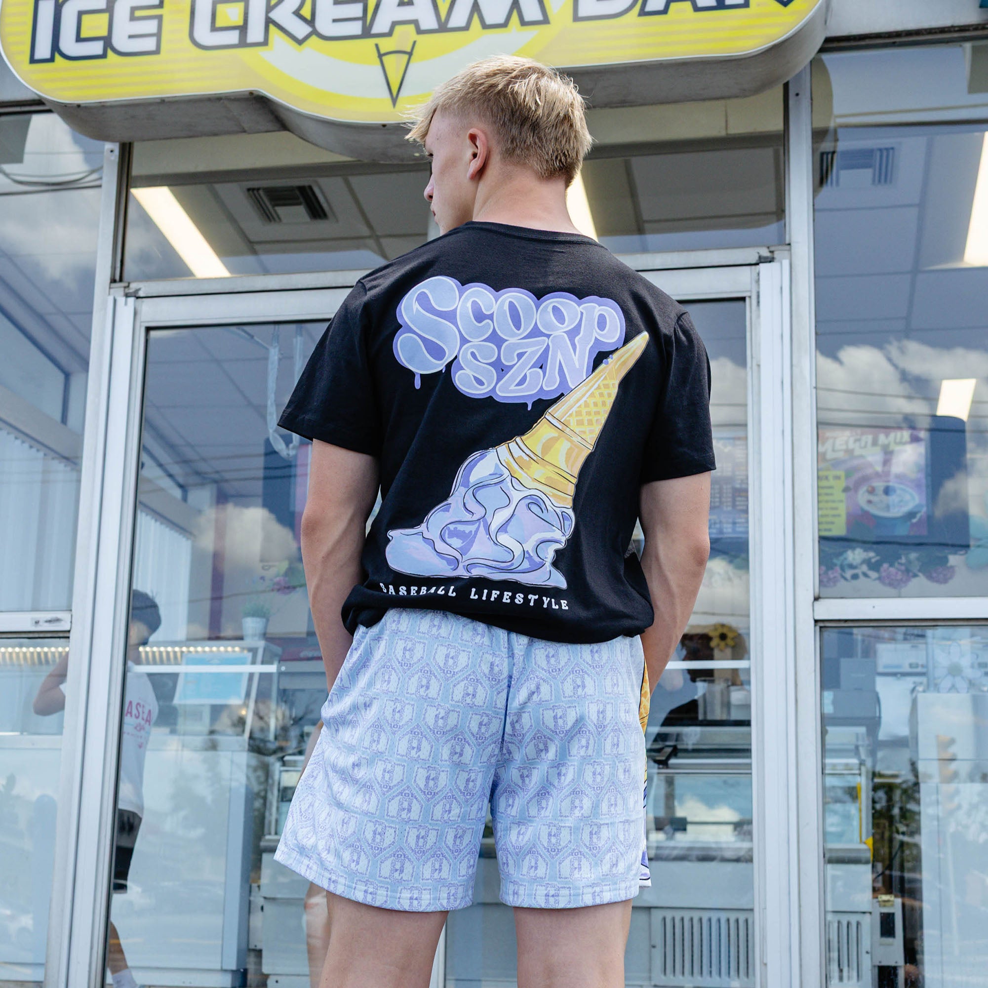 Adult model wearing shorts with "Scoop SZN" design