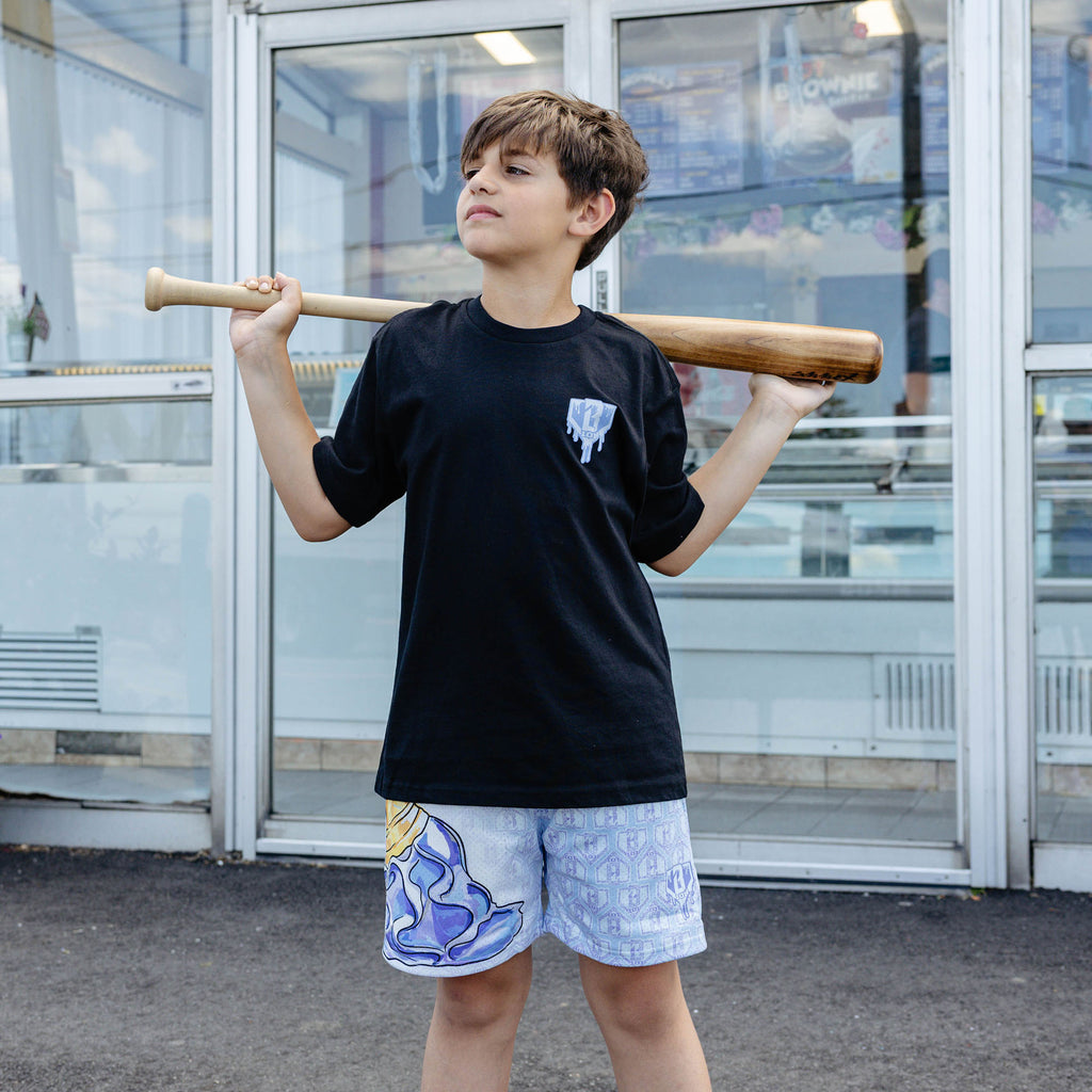Youth model wearing youth shorts with "Scoop SZN" design
